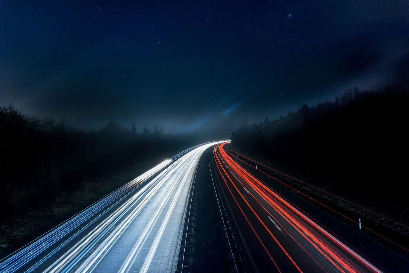 Dâre de lumină pe o autostradă noaptea, cu sensuri separate