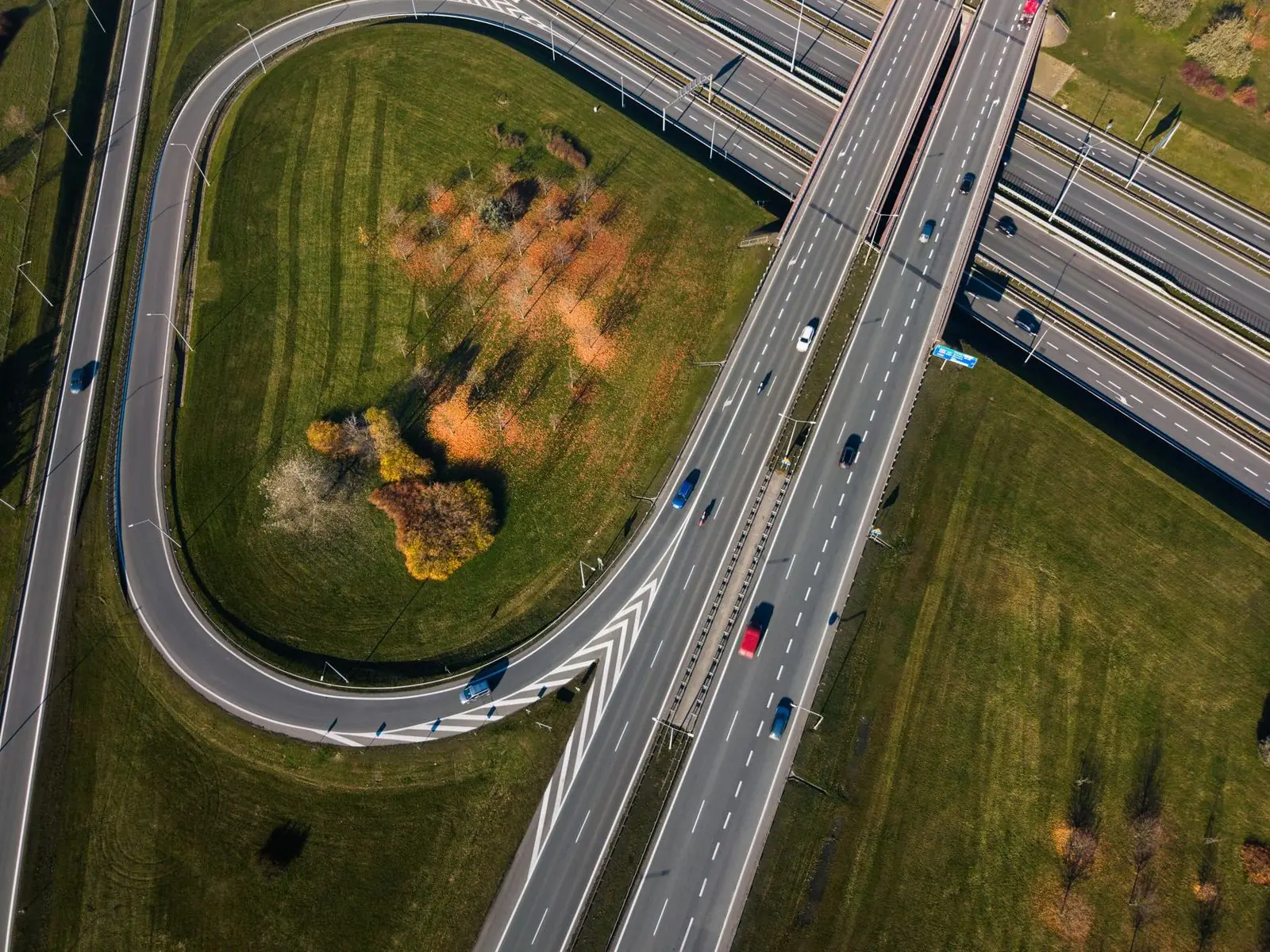 Nod rutier văzut de sus, cu bretele curbe și o autostradă care trece pe deasupra